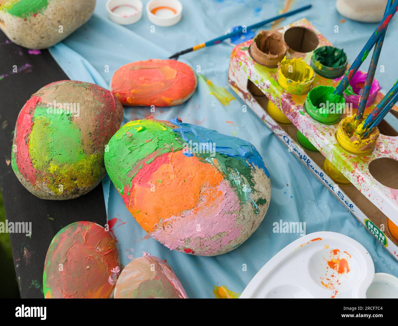Pierres et cailloux aux couleurs vives peints par des enfants à l'aide de peinture acrylique. Banque D'Images
