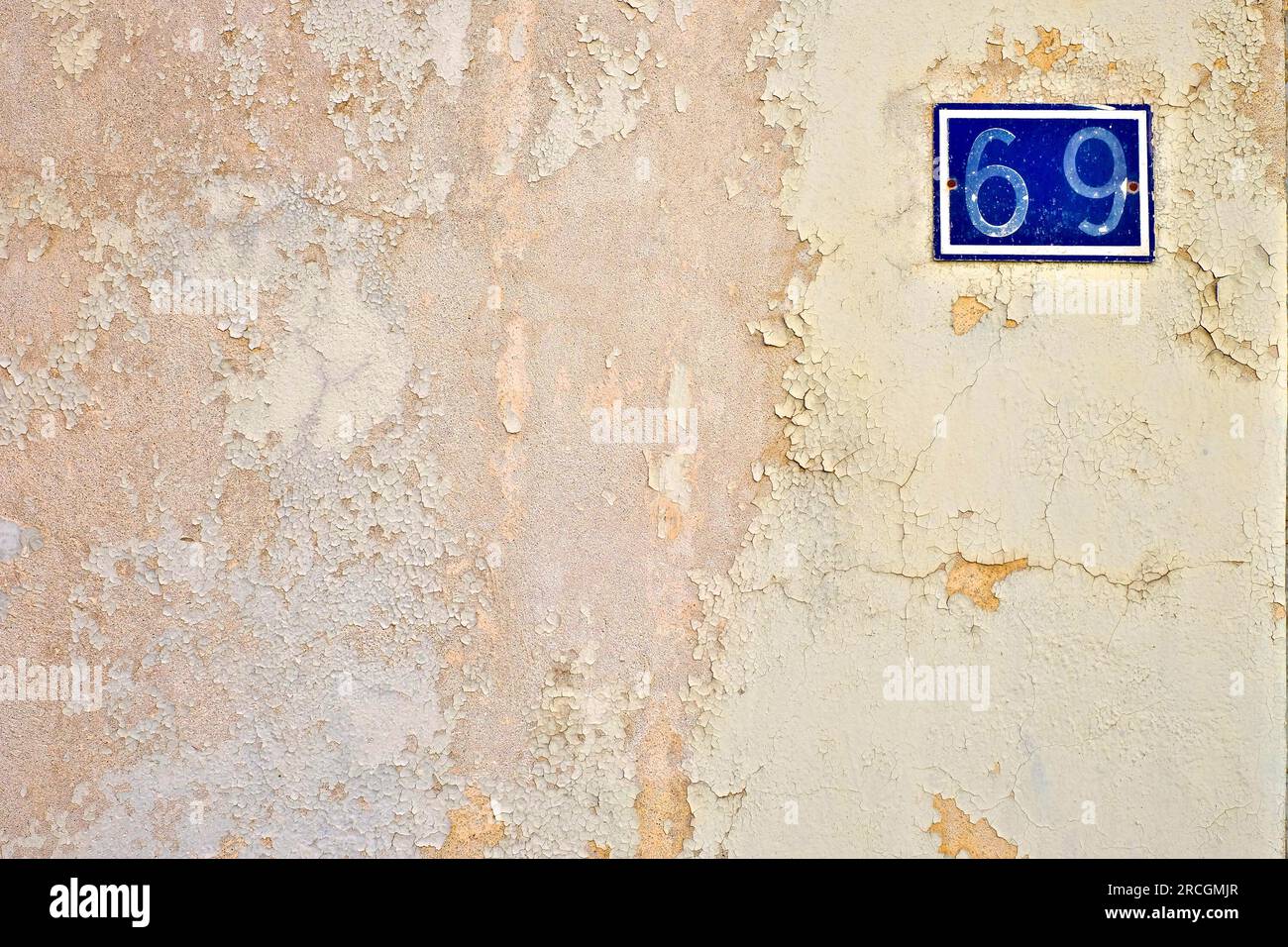 Numéro 69, soixante-neuf, sur une surface murale avec de la peinture altérée. Banque D'Images