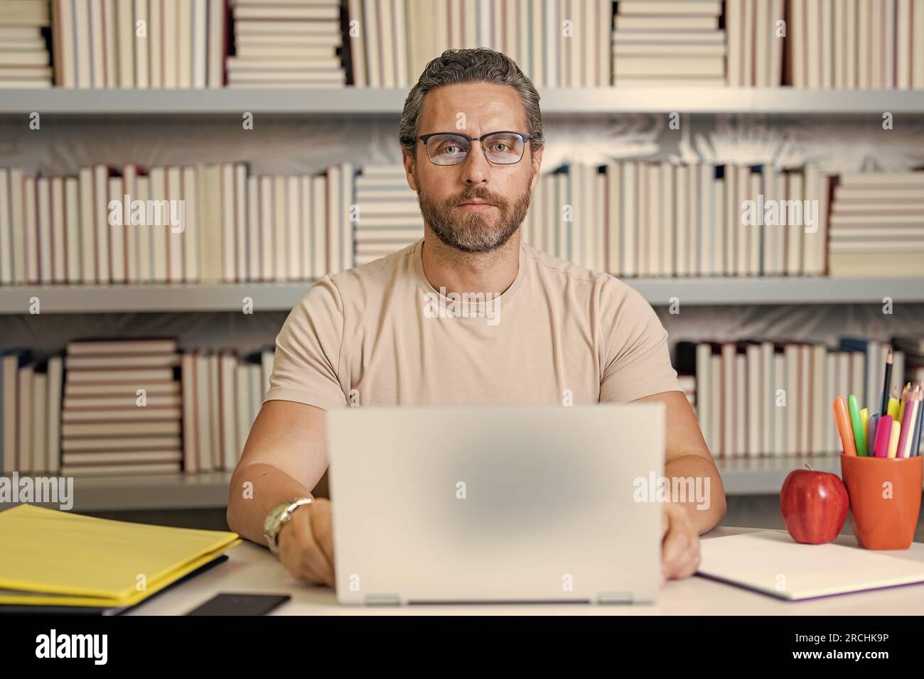 Portrait de l'enseignant de l'école avec ordinateur portable en classe. Beau professeur en classe. Journée des enseignants. Bon enseignant. Formateur en classe. Homme enseignant utilisant Banque D'Images