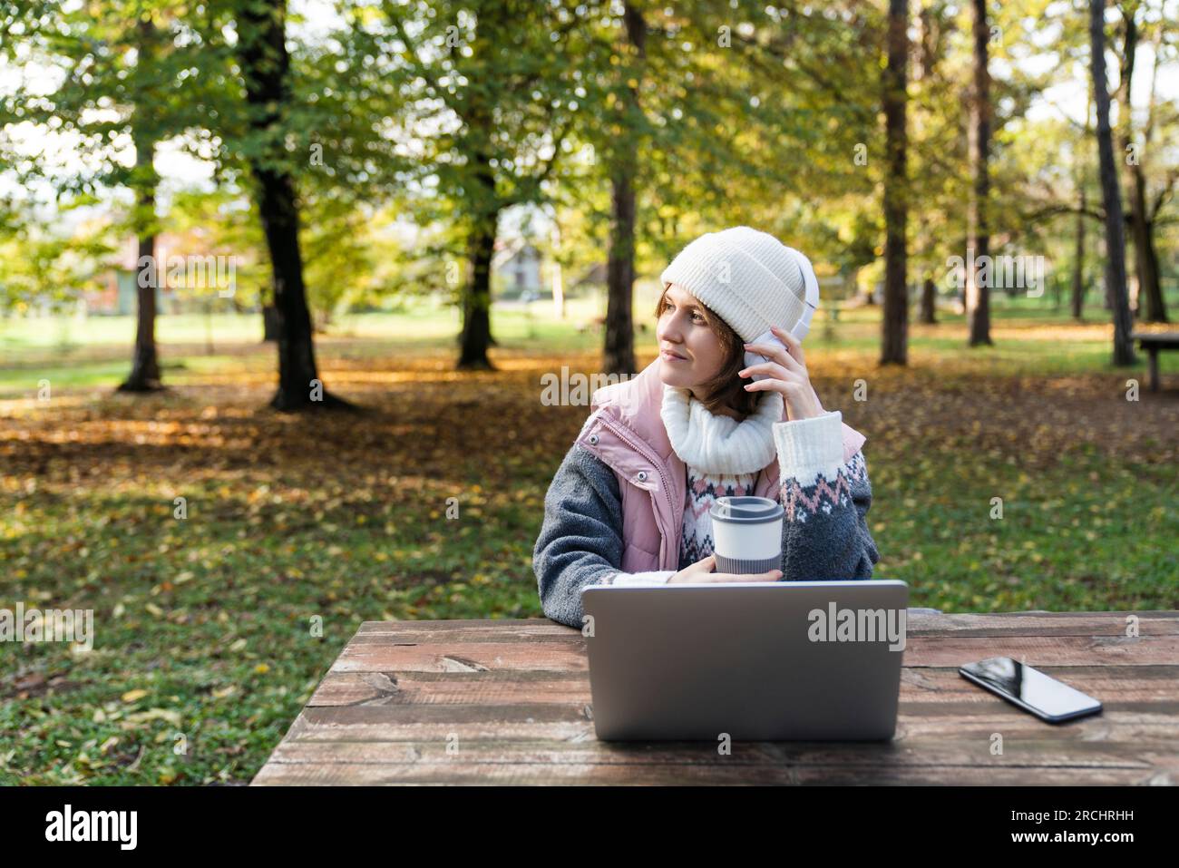 Travailleur indépendant travaillant sur ordinateur portable dans le parc d'automne. Banque D'Images