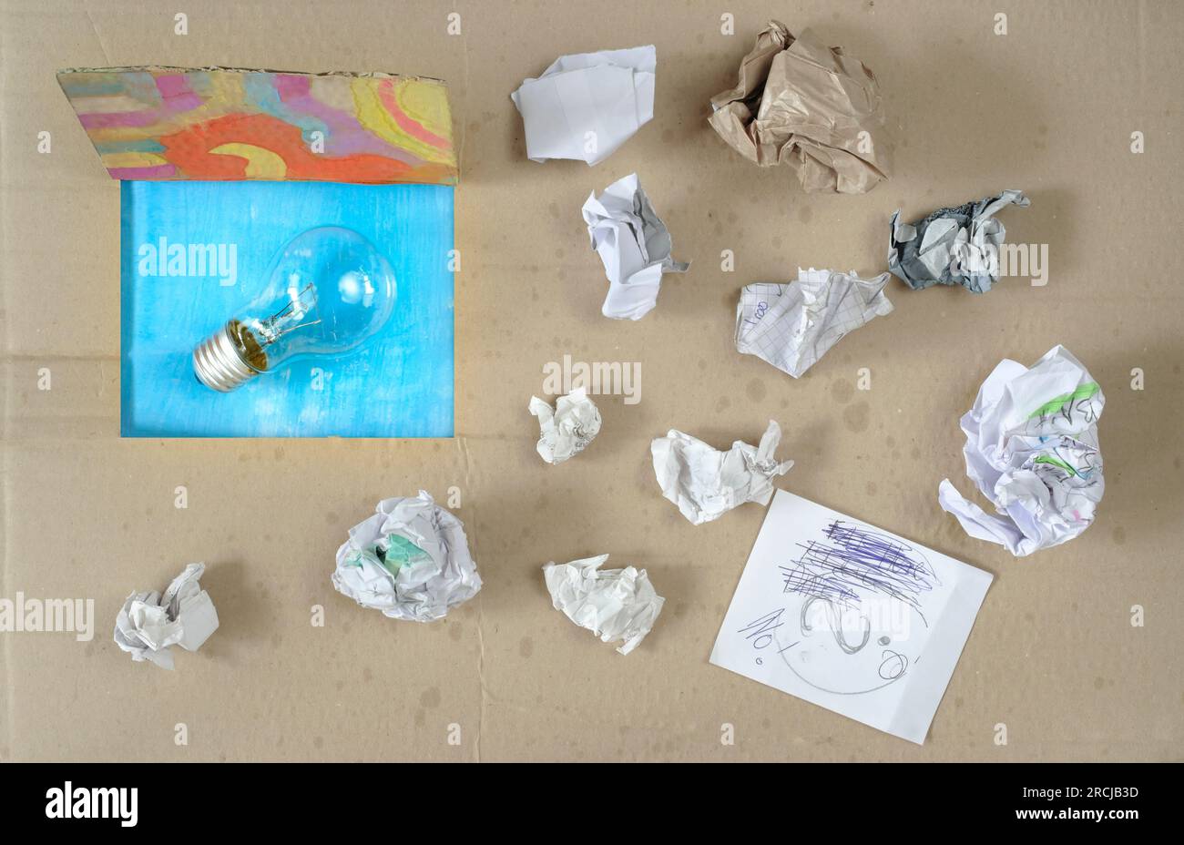 Penser à l'extérieur de la boîte, innovation, idée, vision, concept d'affaires, boîte grundy avec papier froissé et ampoule, symbolique et méataphorique Banque D'Images