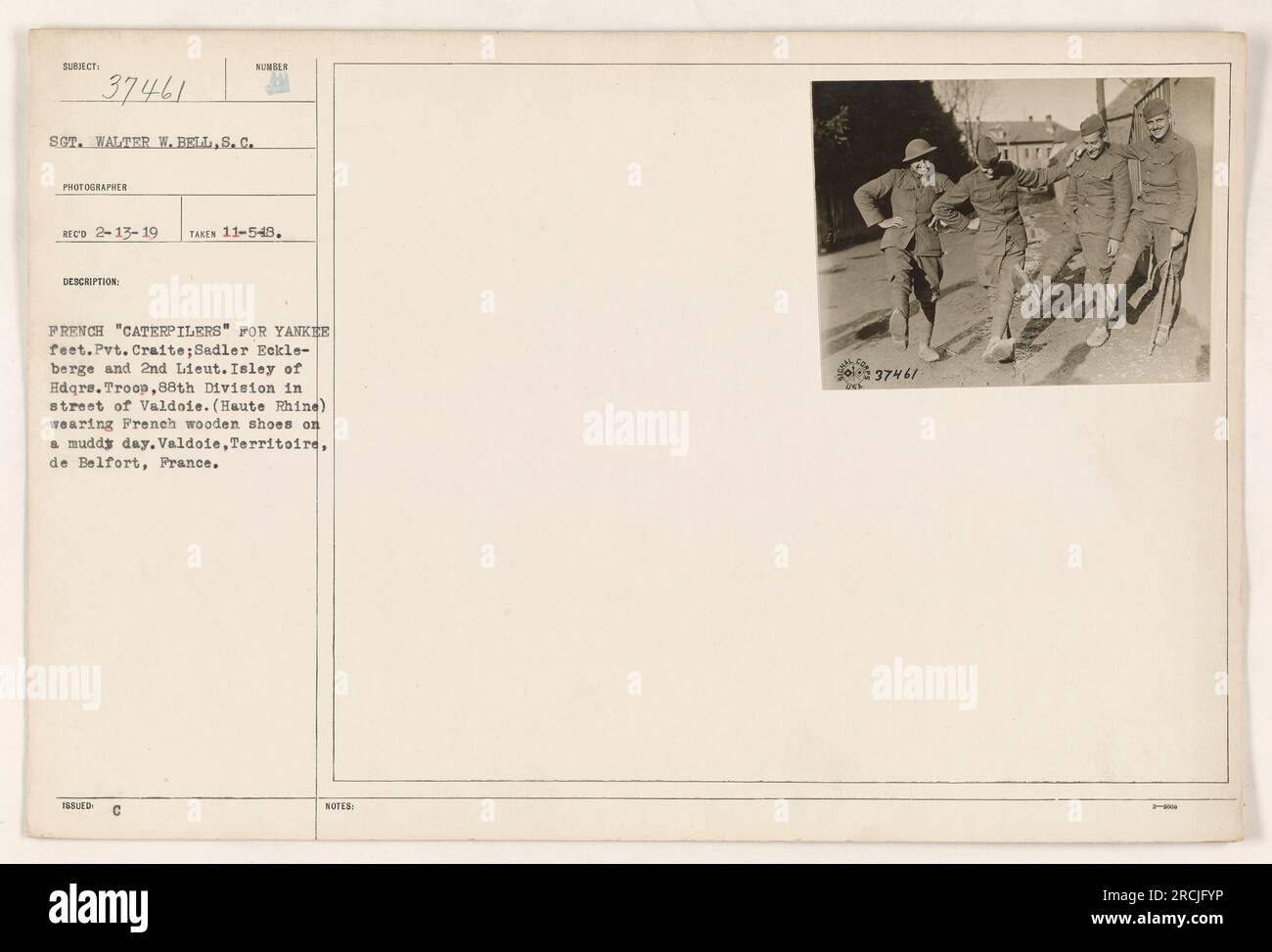 Les soldats américains de la 88e division portant des chaussures françaises en bois, connues sous le nom de « caterpillers », naviguent dans les rues boueuses de Valdoie, en France, pendant la première Guerre mondiale Les soldats photographiés comprennent le soldat Craite, Sadler Eckle-berge, et le 2nd Lt Isley de la troupe du quartier général. La photographie a été prise par le sergent Walter W. Bell le 5 novembre 1949. Banque D'Images