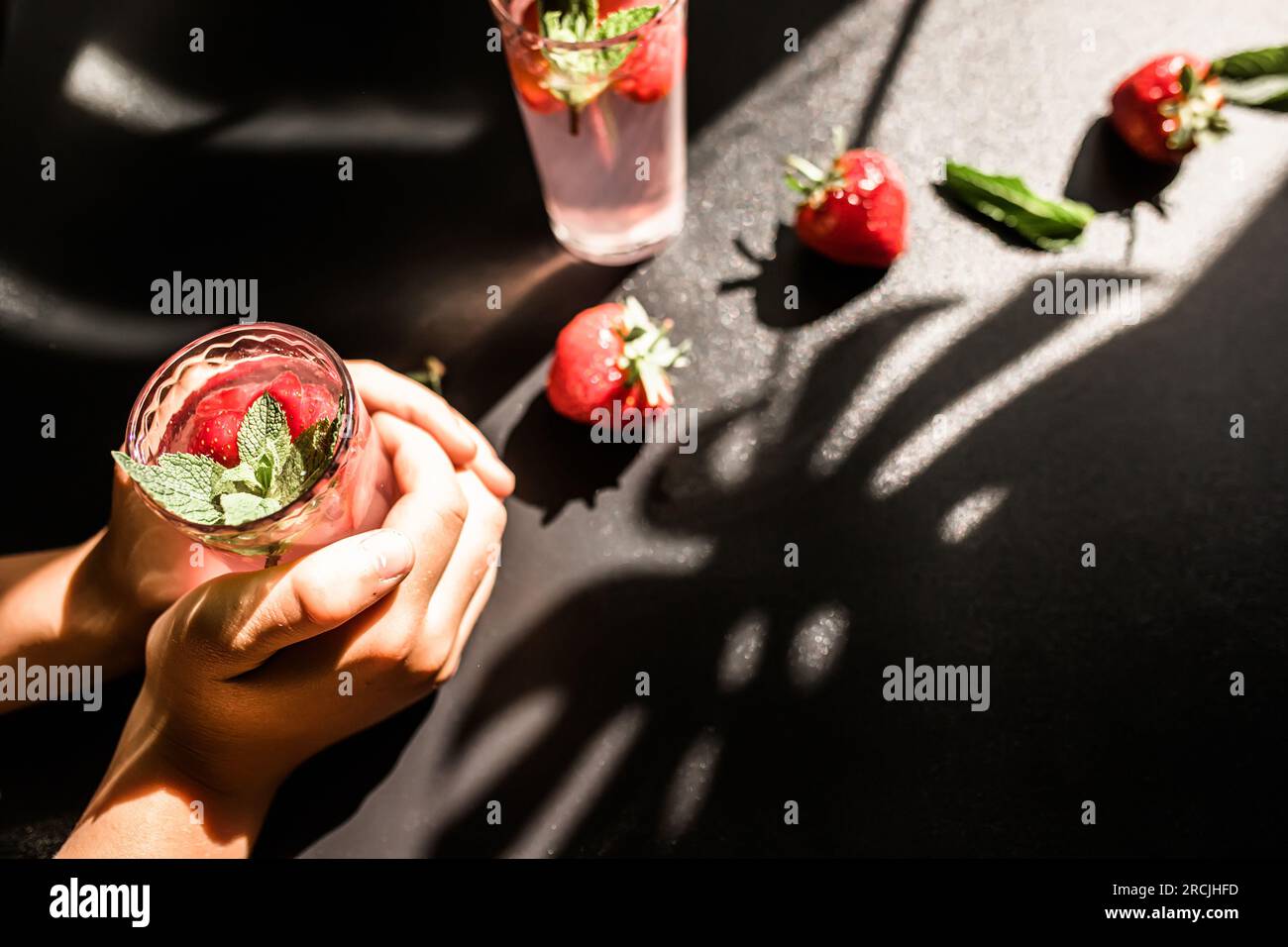 Thé glacé aux fraises. Une boisson rafraîchissante et saine pour les chaudes journées d'été. Thé à la fraise maison versé sur des glaçons dans un verre, offrant un éclat de Banque D'Images