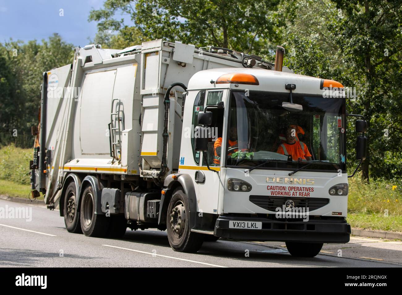 Milton Keynes, Royaume-Uni - 13 juillet 2023 : 2013 camion à ordures blanc Dennis conduisant sur une route anglaise. Banque D'Images
