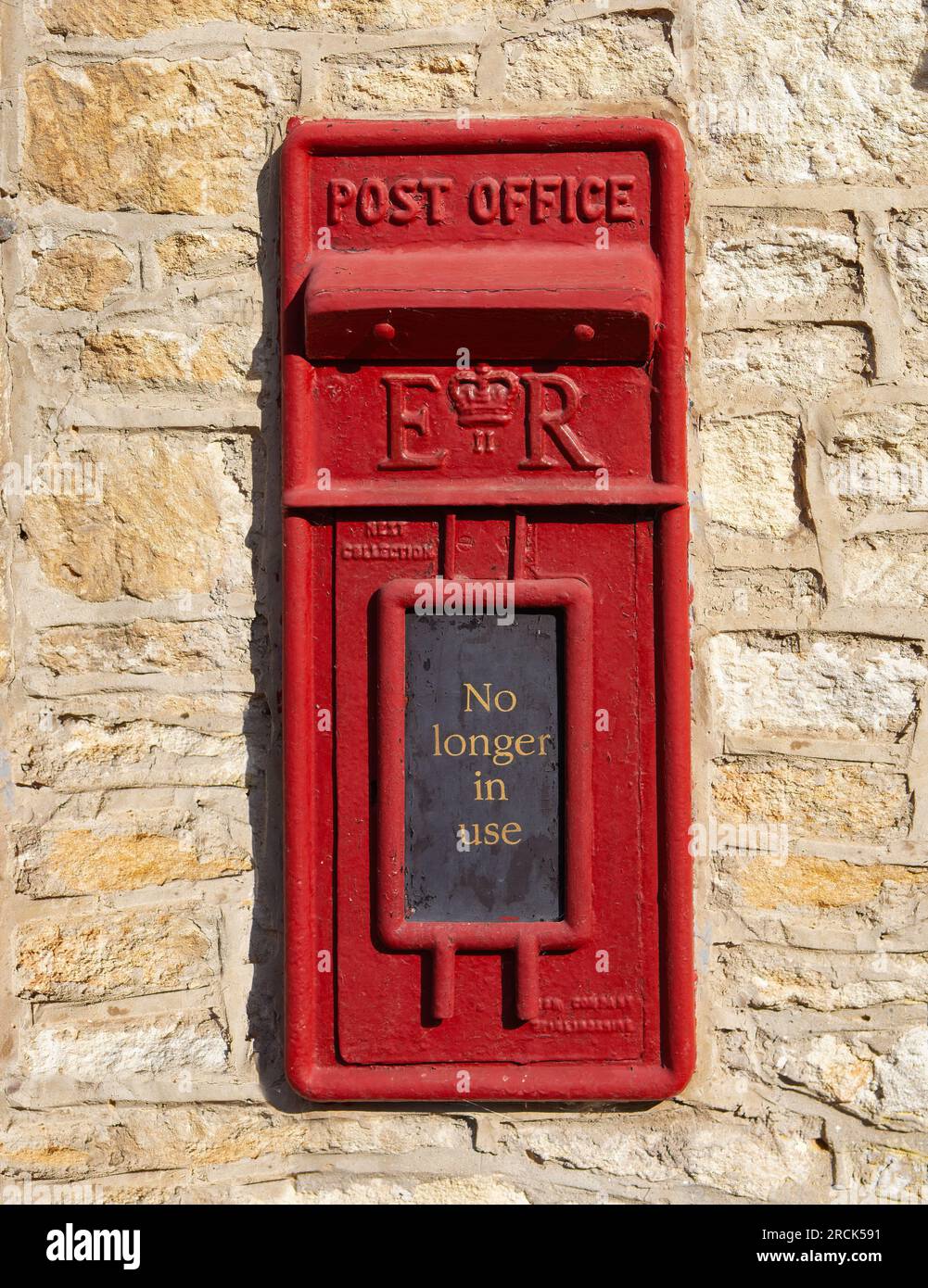 Vieille boîte aux lettres rouge au château de Combe dans les Cotswolds, Angleterre à la fin de l'été. Banque D'Images