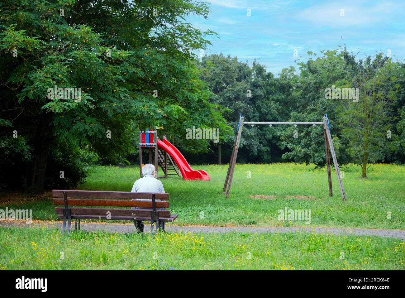 Un vieil homme se repose assis sur le banc dans le parc Banque D'Images
