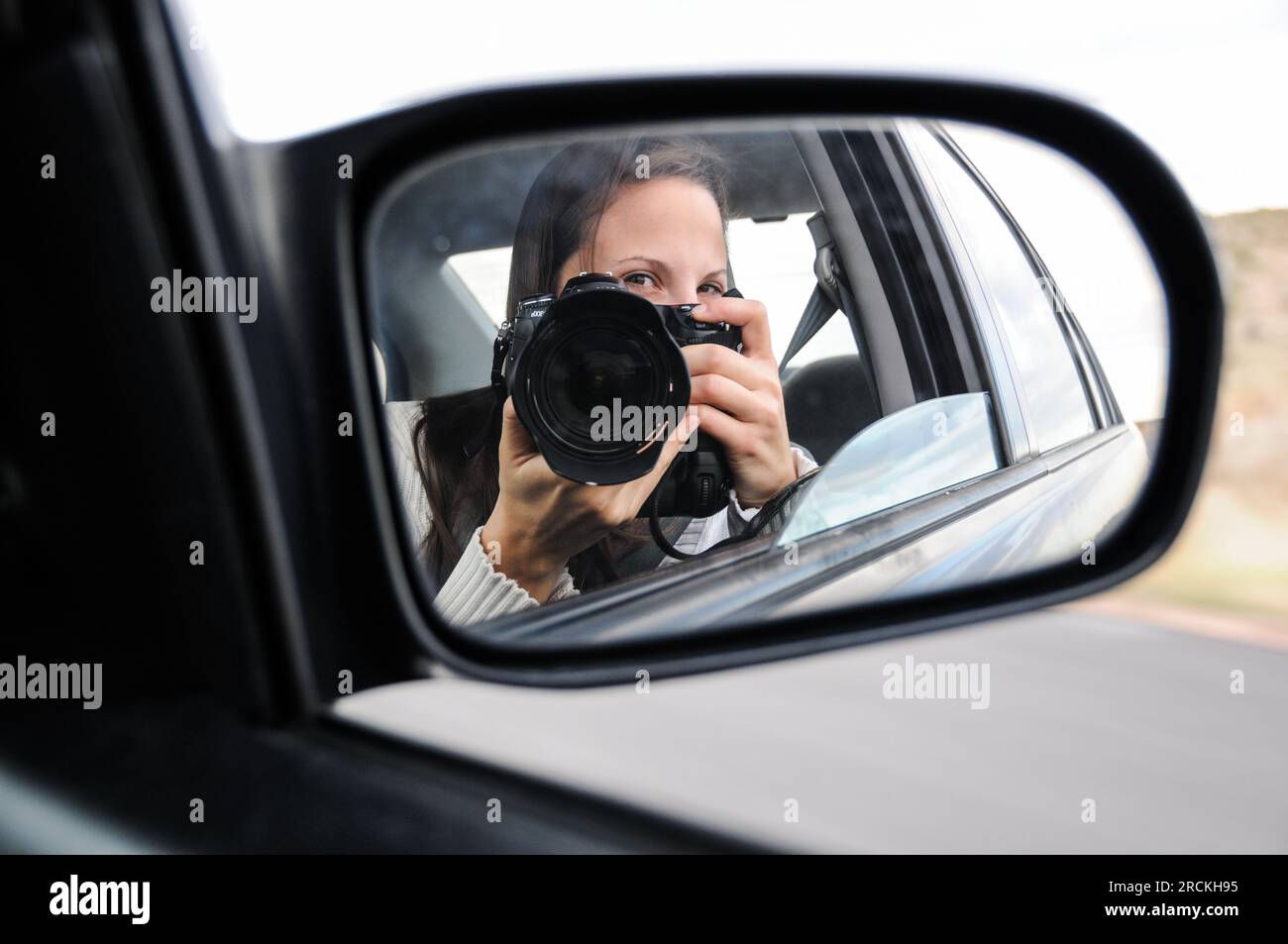 Autoportrait d'une fille dans un miroir de voiture lors d'un voyage en voiture à travers le midwest américain Banque D'Images
