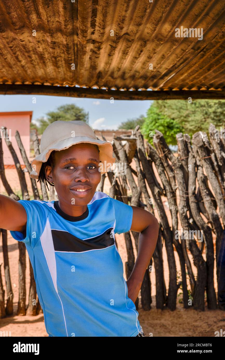 jeune femme africaine de village avec un chapeau debout sous l'ombre d'une cabane pour se rafraîchir Banque D'Images