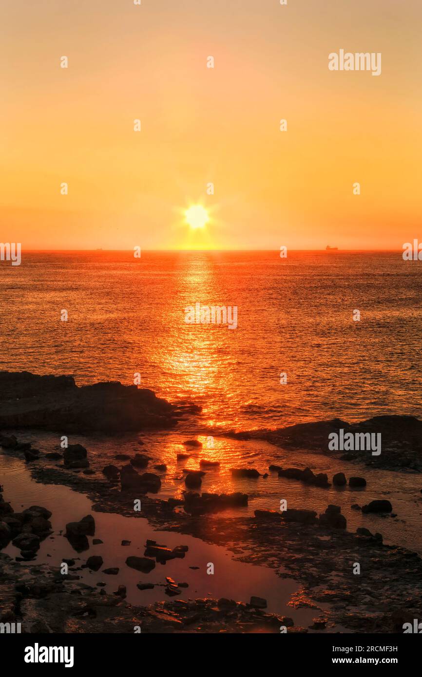 Lever de soleil pittoresque coloré sur l'horizon de l'océan Pacifique depuis Swansea Head en Australie. Banque D'Images