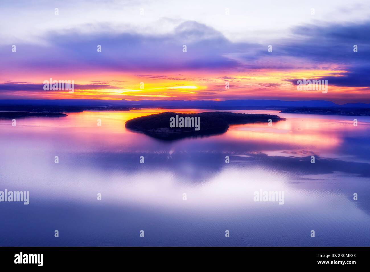 Coucher de soleil pittoresque coloré sur l'île de Dangar sur le miroir calme du lac Macquarie Pacific Ocean Lagoon en Australie. Banque D'Images