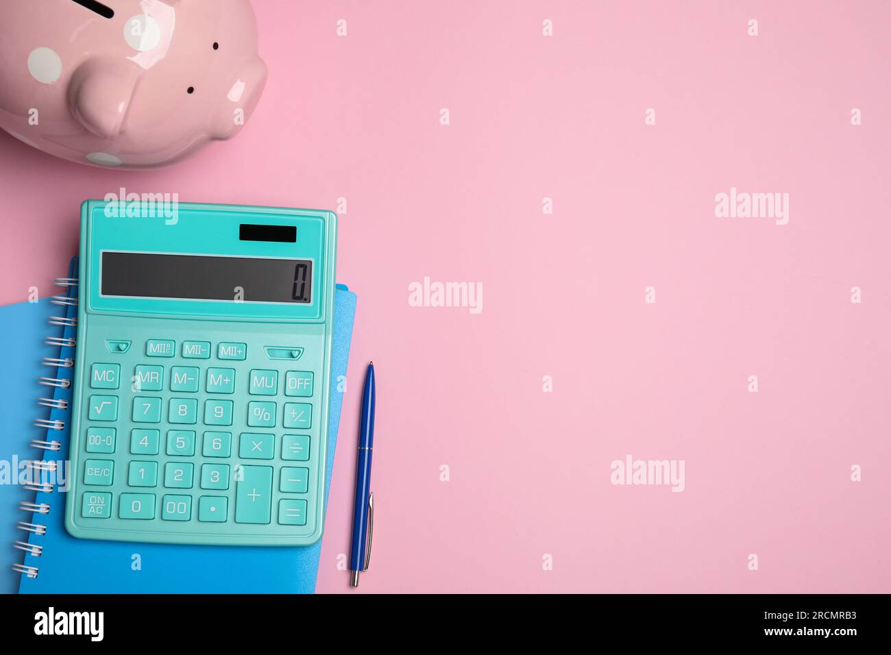 Calculatrice, tirelire, cahiers et stylo sur fond rose, plat avec espace pour le texte Banque D'Images