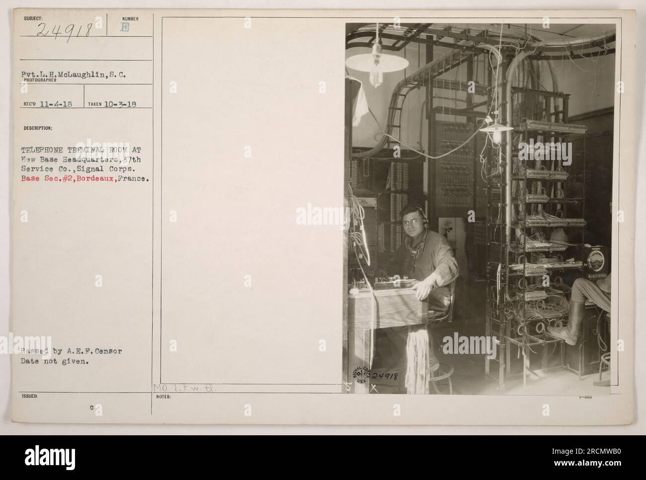 CÔTÉ GAUCHE Pvt McLaughlin est photographié à l'intérieur de la salle du terminal téléphonique au quartier général de la base TEW, 37th Service Co., signal corps. Base sec. No 2, Bordeaux, France. La photographie a été prise le 10-3-18 et approuvée par le censeur de l'A.E.P. Aucune note ou information supplémentaire n'est fournie. Banque D'Images