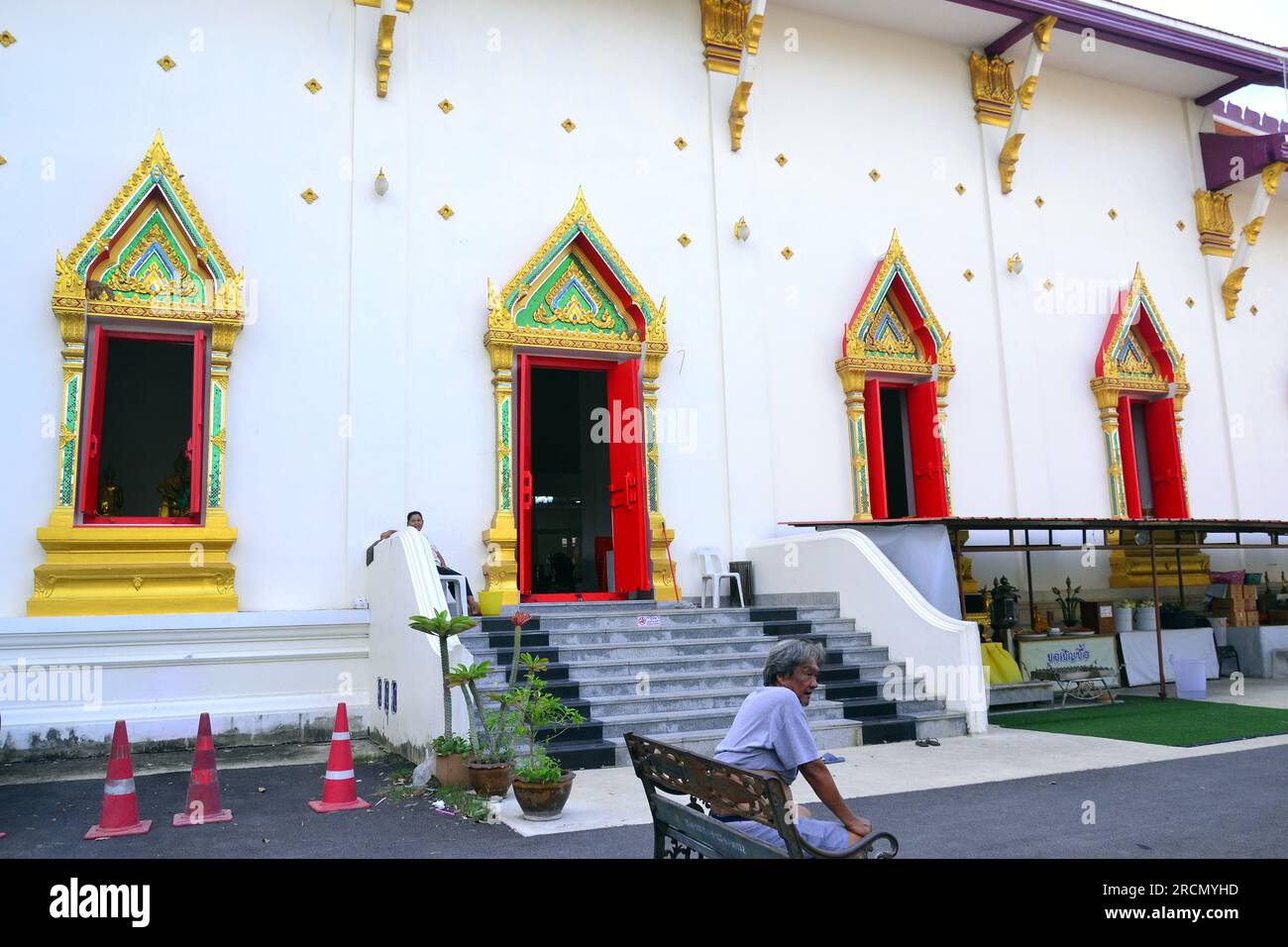 Un homme est assis devant Wat Kaew Fah Chulamanee, un temple bouddhiste à Bangkok, en Thaïlande Banque D'Images