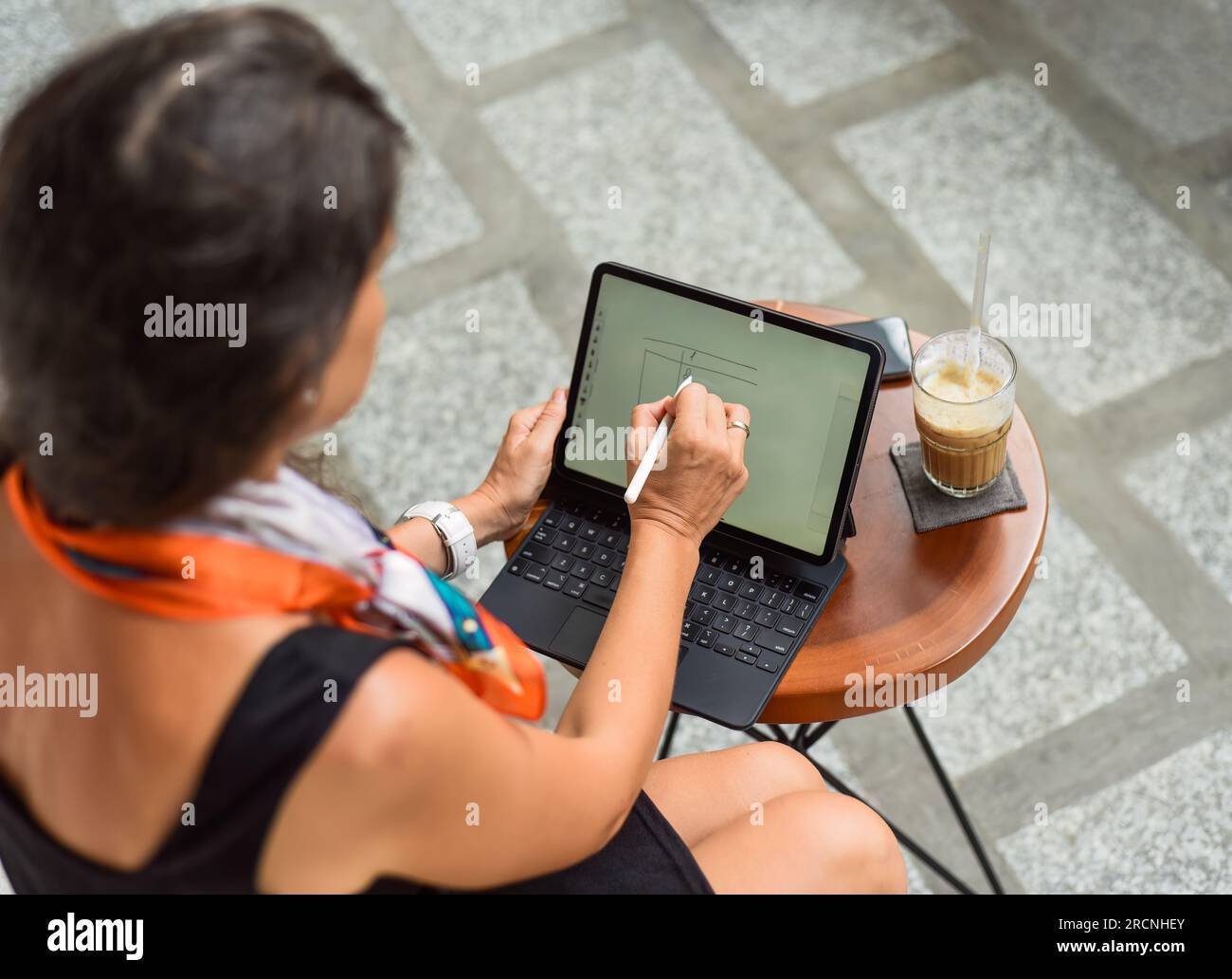 Jeune femme faisant la planification financière dans la tablette avec stylet Banque D'Images