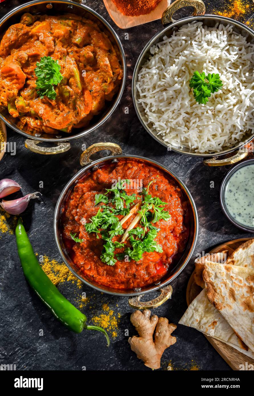 Paneer de madras chaud et masala de légumes avec riz basmati servi dans des pots de karahi indiens originaux. Banque D'Images