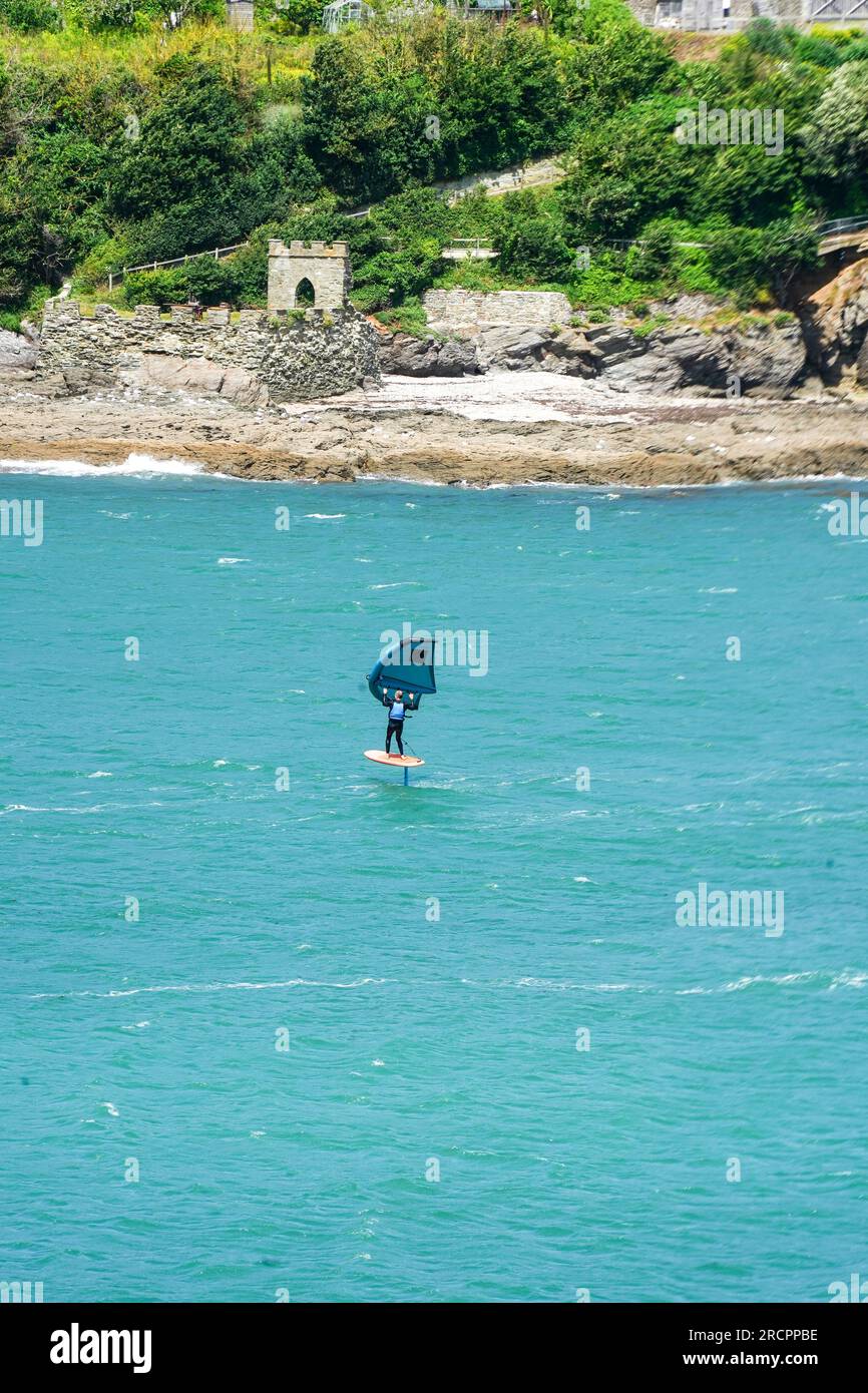 Salcombe, Devon, Royaume-Uni - 15 juillet 2023 : surfer Wing se déjoue sur une planche d'hydroptère gonflable au port de Salcombe dans le sud du Devon, Royaume-Uni Banque D'Images