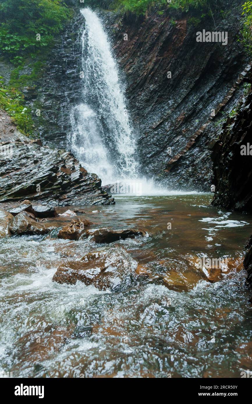 Cascade de montagne, grande chute d'eau, rivière de montagne près de la roche. Cascade Huk, Carpates ukrainiennes Banque D'Images