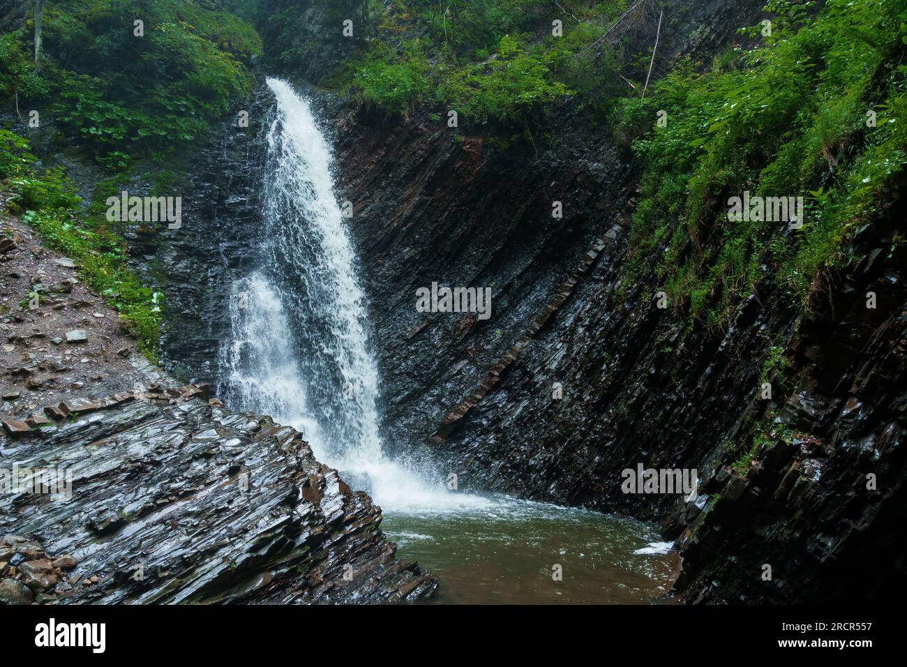 Cascade de montagne, grande chute d'eau, rivière de montagne près de la roche. Cascade Huk, Carpates ukrainiennes Banque D'Images