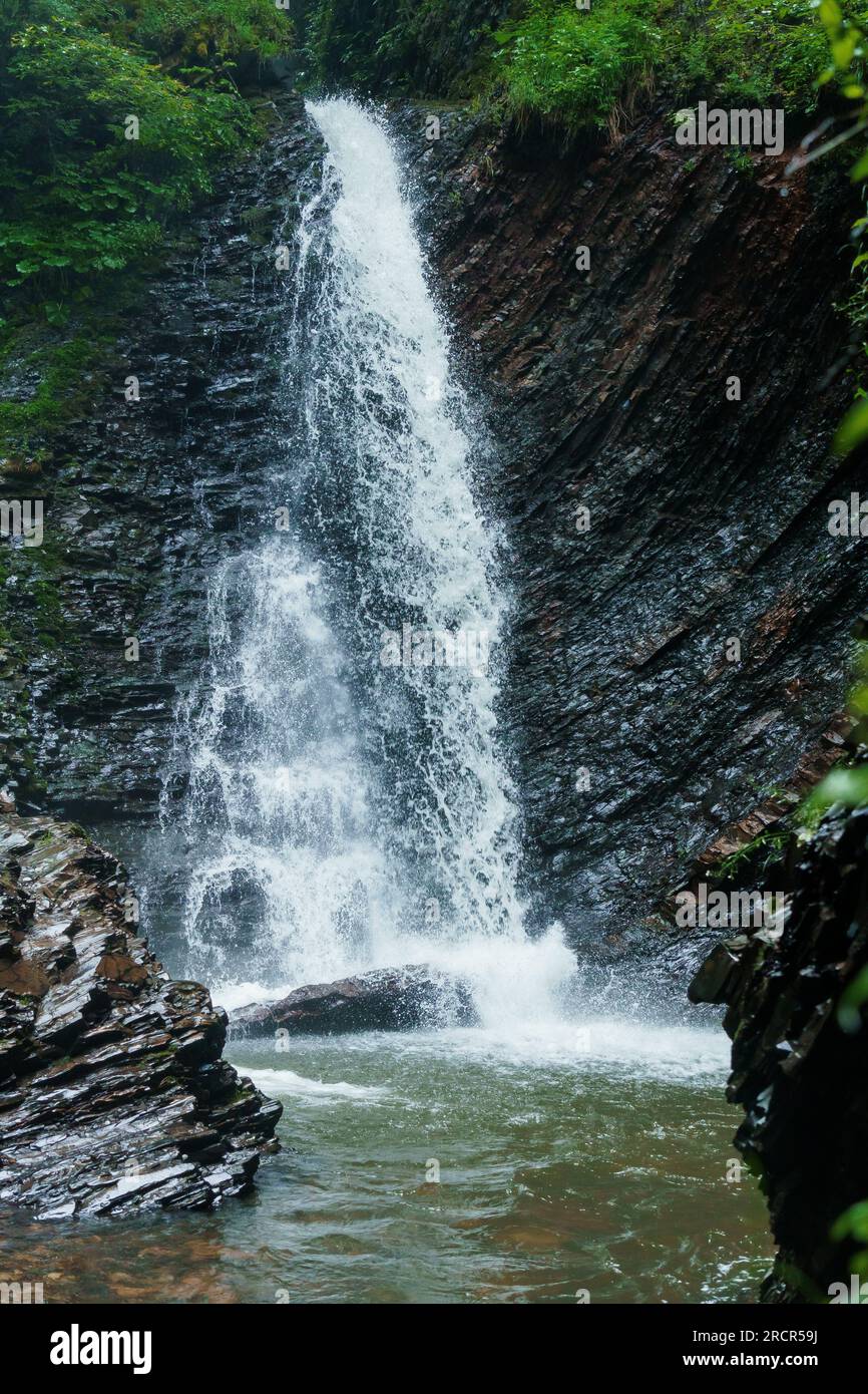 Cascade de montagne, grande chute d'eau, rivière de montagne près de la roche. Cascade Huk, Carpates ukrainiennes Banque D'Images