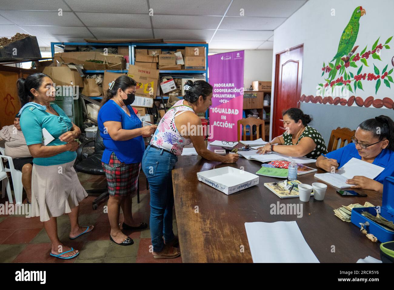 El Espino, la Libertad, El Salvador - octobre 11 2022 : des femmes font la queue pour payer les autres à une table et compter l'argent lors d'un Meetin de groupe d'épargne communautaire Banque D'Images