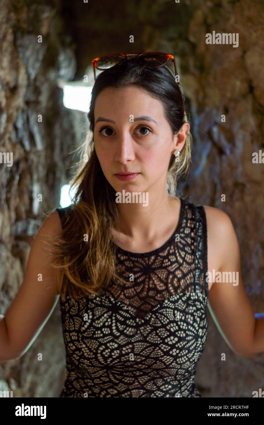 Jeune femme brune européenne regardant sérieusement la caméra. Portrait de femme portant des lunettes de soleil sur sa tête Banque D'Images