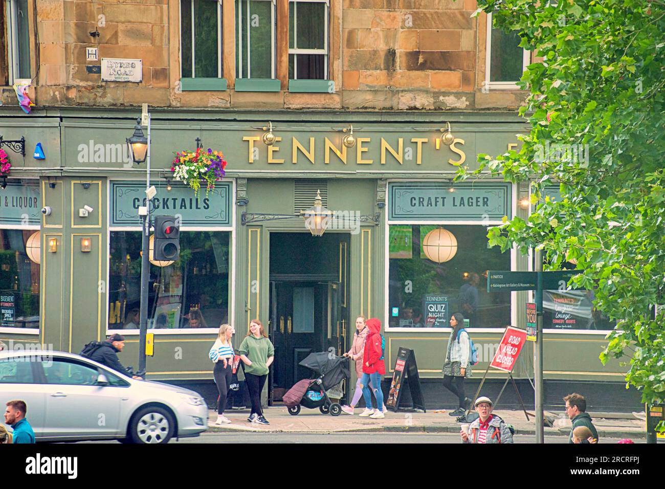 Glasgow, Écosse, Royaume-Uni 16 juillet 2023. UK Météo : temps chaud et humide et une sensation générale de dystopie ont vu les gens prendre les rues de la ville. Le célèbre bar Tennents ob byres Road. Crédit Gerard Ferry/Alamy Live News Banque D'Images