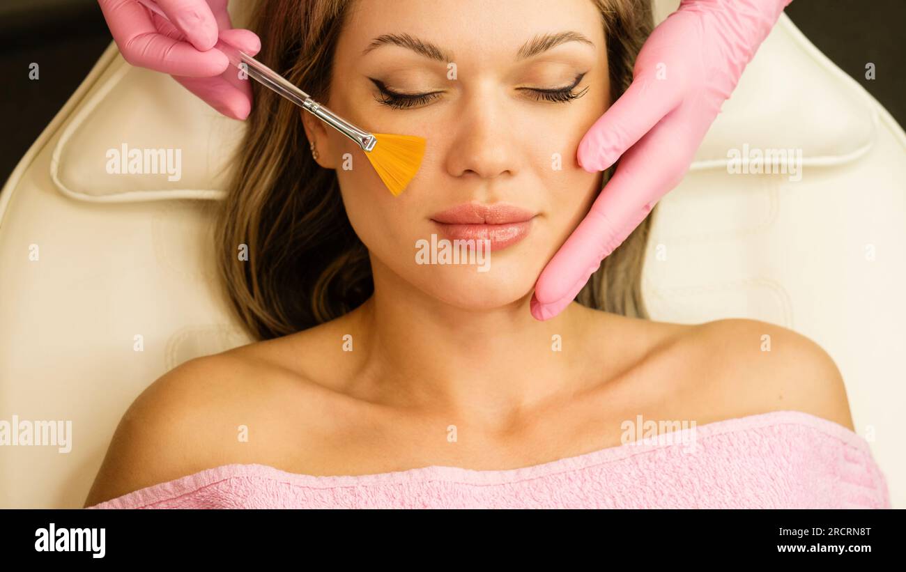 Jeune femme pendant la procédure de peeling du visage dans le salon de beauté. Peeling chimique du visage Banque D'Images