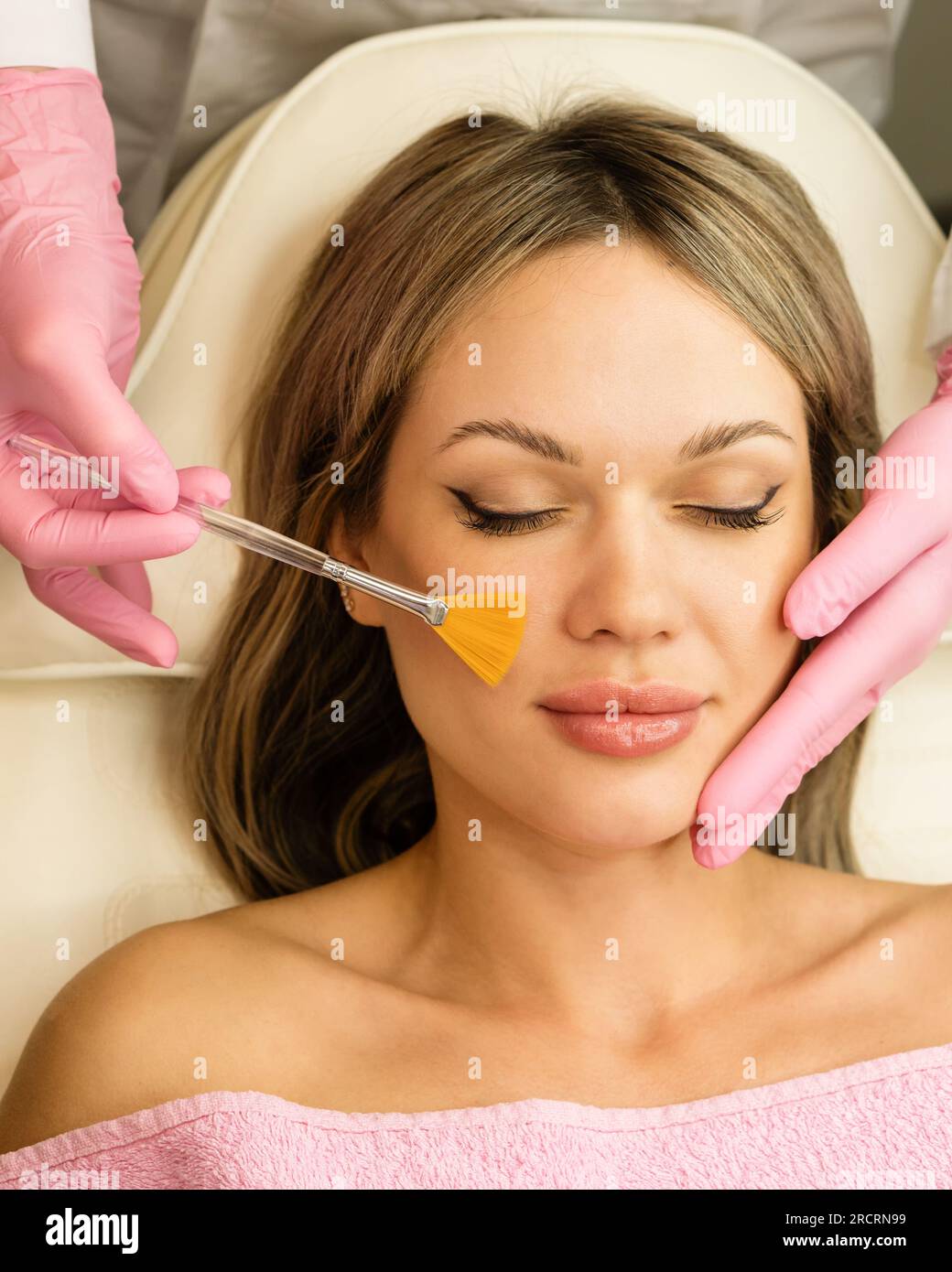 Jeune femme pendant la procédure de peeling du visage dans le salon de beauté. Peeling chimique du visage Banque D'Images