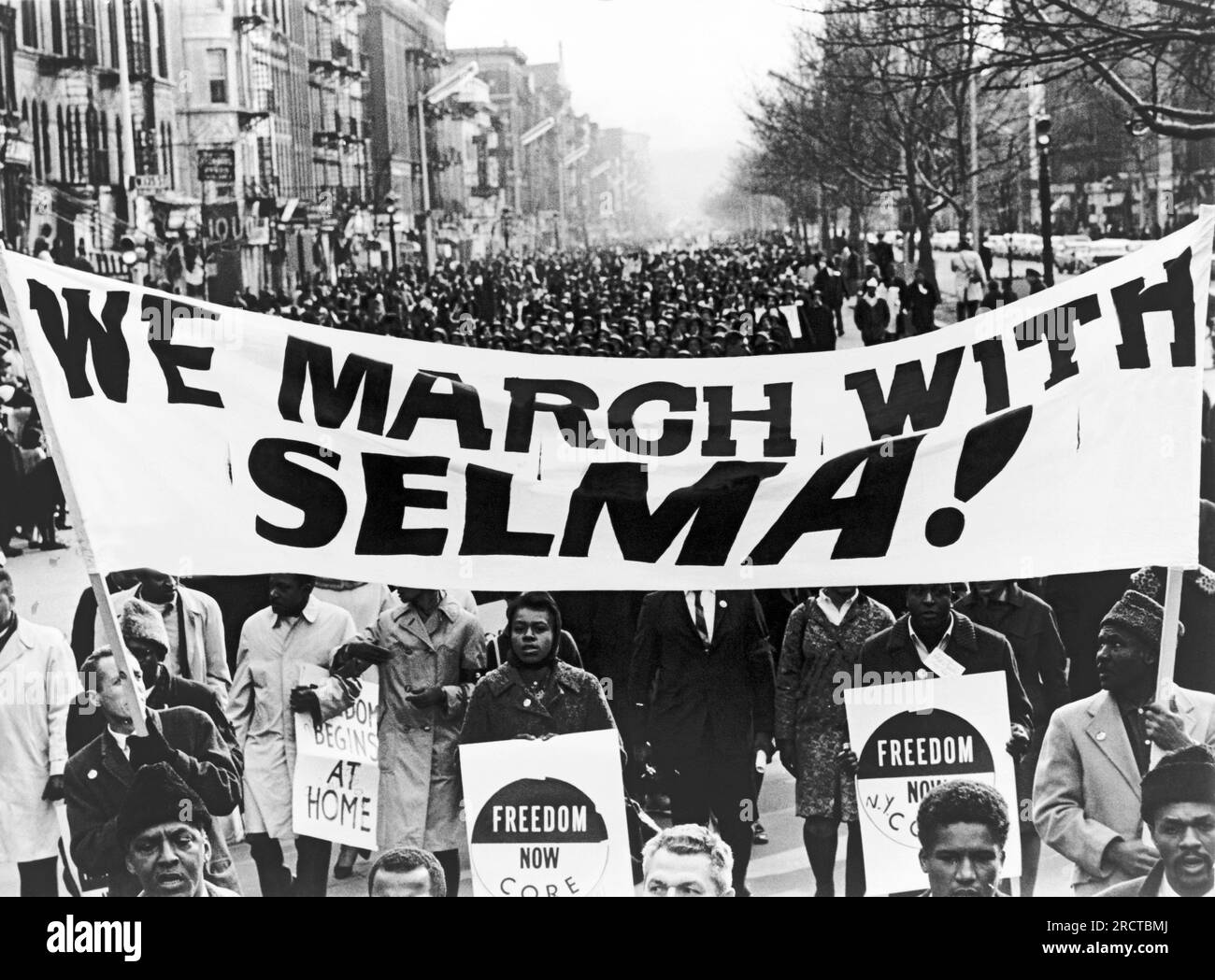 New York, New York : 15 mars 1965 des marcheurs des droits civiques portant une bannière, 'nous marchons avec Selma!' Ouvrez la voie alors que 15 000 personnes défilent dans Harlem Street. Banque D'Images