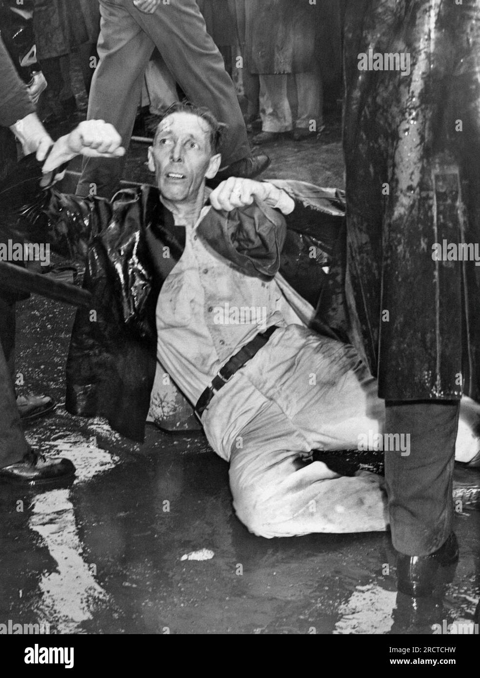 Los Angeles, Californie : 1 octobre 1946. Un manifestant blessé aux studios MGM se trouve sur le trottoir alors qu'un policier le tient. De nombreux paradisiaques sont des anciens combattants qui ont été mis en lock-out pendant la grève. Banque D'Images