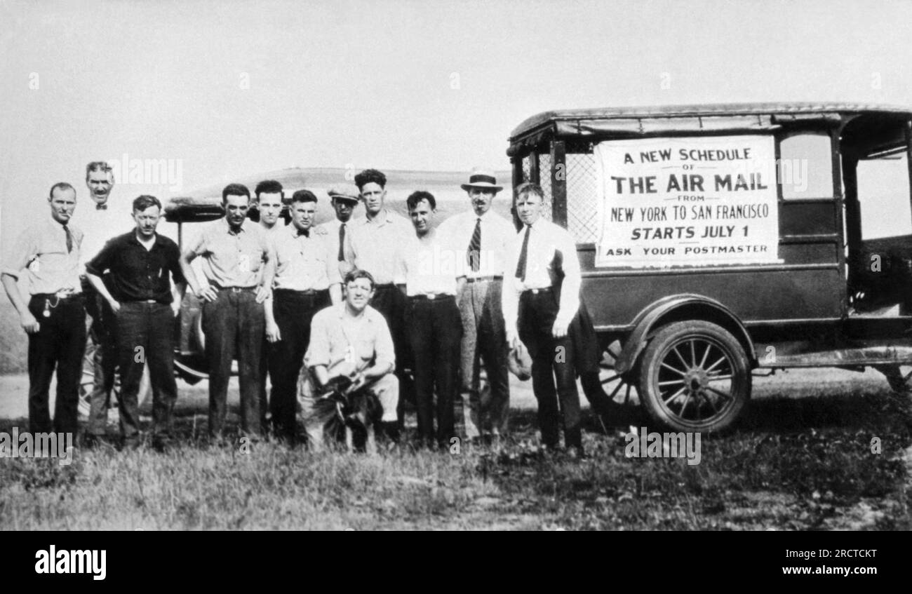 Garden City, New York : 1924 fonctionnaires du bureau de poste des États-Unis à Hazelhurst Field sur long Island avec un panneau sur un véhicule annonçant le nouvel horaire de courrier aérien entre New York et San Francisco. Les horaires précédents de la poste aérienne ne permettaient de voler que pendant la journée, mais les progrès ont permis de voler également la nuit, réduisant le temps de 70 heures à moins de 34 heures entre Hazelhurst Field et Crissy Field à San Francisco. Banque D'Images