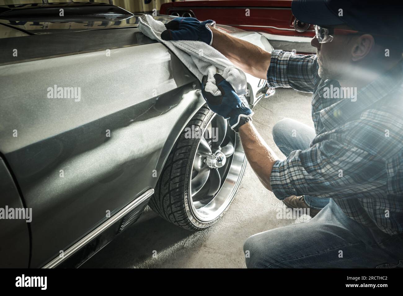 Propriétaire de voitures classiques caucasiennes nettoyant ses voitures musculaires américaines. Thème automobile. Banque D'Images