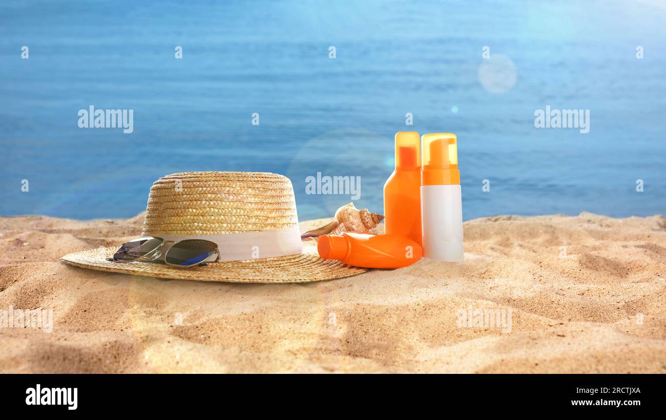 Chapeau avec lunettes de soleil et cosmétiques sur la plage ensoleillée de l'océan, conception de bannière. Vacances d'été Banque D'Images