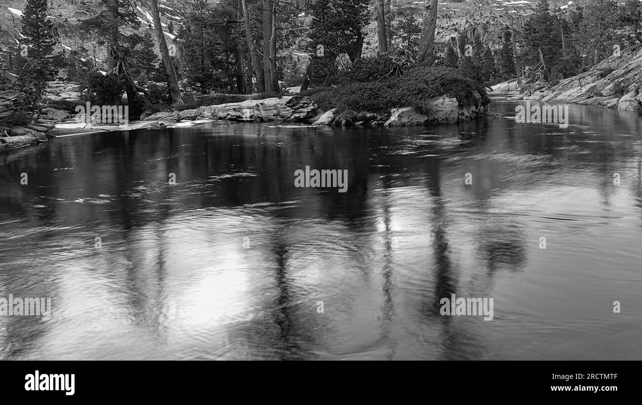 reflets du ciel et des arbres dans l'eau calme du lac. Banque D'Images