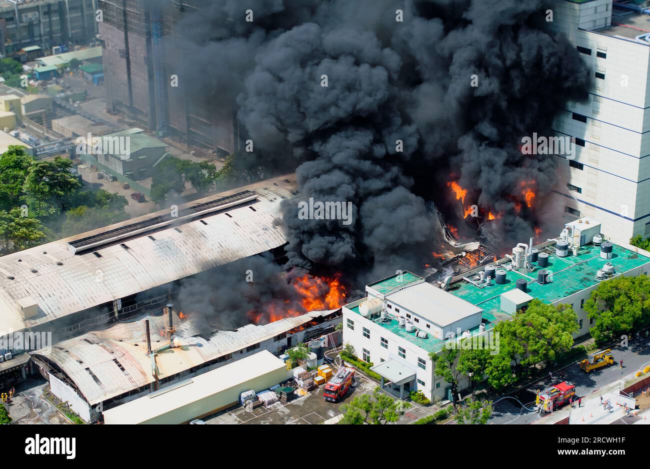 Vue aérienne d'incendie dans un bâtiment industriel. Hangar en béton à plusieurs étages avec flammes. Concept d'urgence d'usine. Banque D'Images