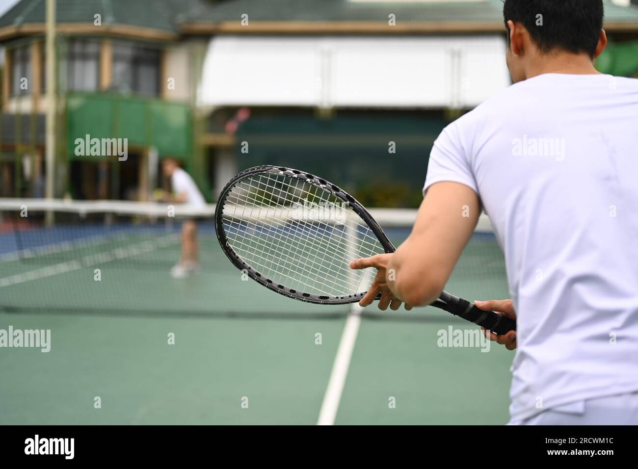 Joueur de tennis homme debout en position prête à recevoir un service, pratiquant pour la compétition sur un court Banque D'Images