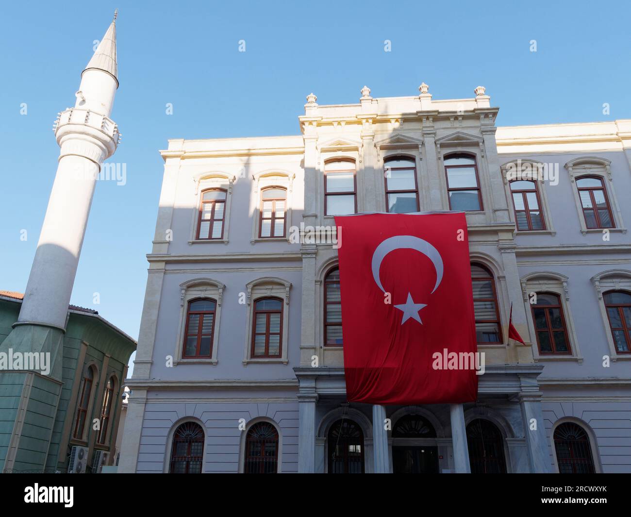 Bâtiment avec un drapeau turc accroché à l'avant et un minaret à gauche, Istanbul, Turquie Banque D'Images