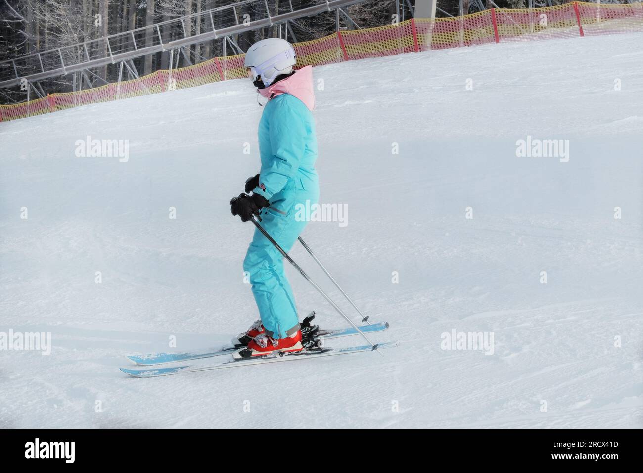 Skieur en combinaison de ski bleu se lève sur l'ascenseur vers le haut de la pente de montagne. Sports de ski en hiver. Vacances en montagne dans la station de ski. Banque D'Images