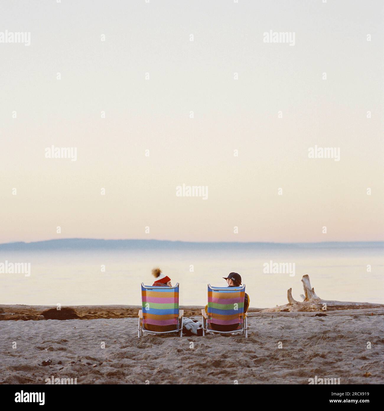 Couple assis sur la plage dans le froid hiver de Seattle Banque D'Images