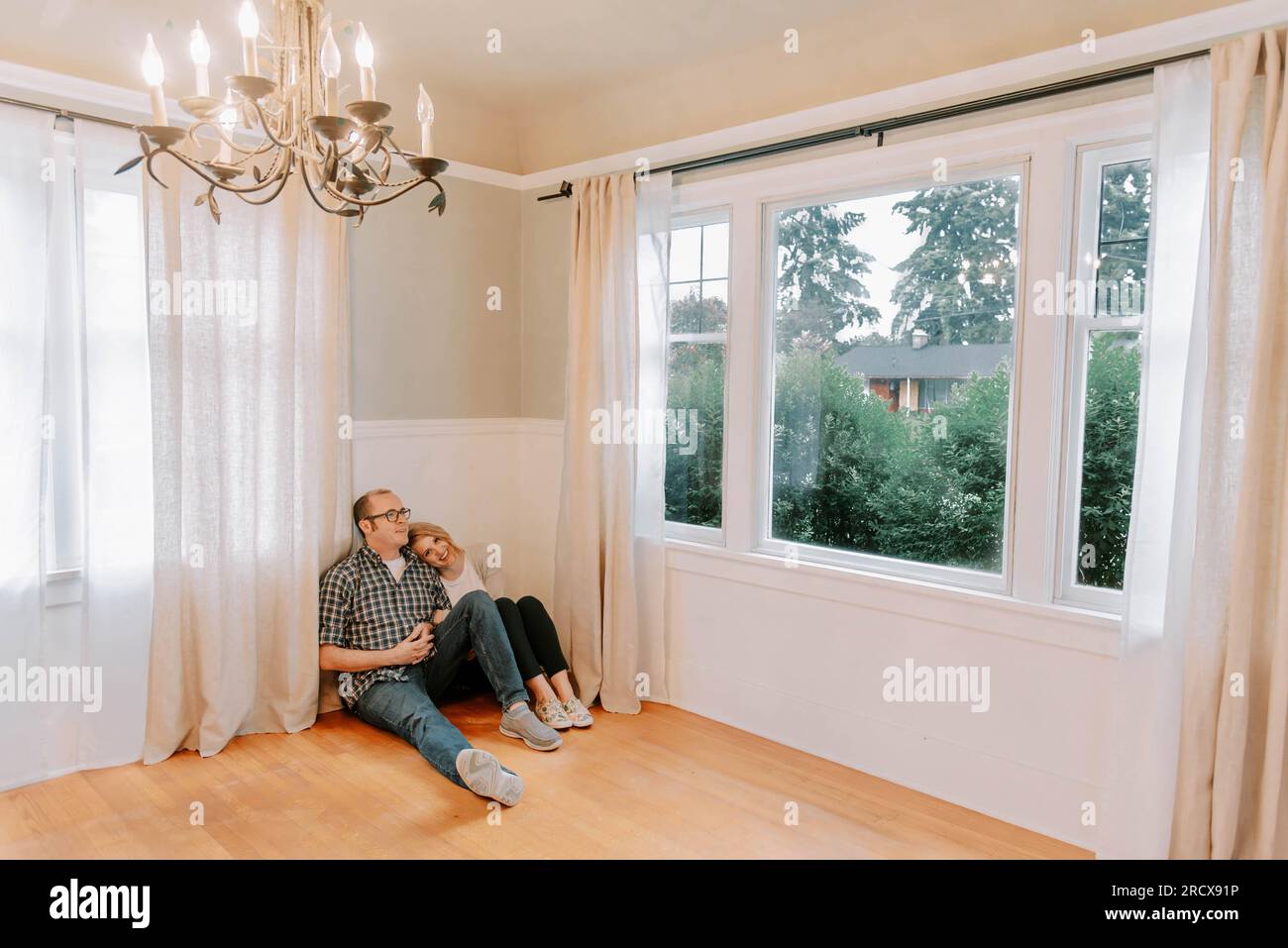 couple profitant d'un moment tendre dans leur nouvelle maison vide Banque D'Images