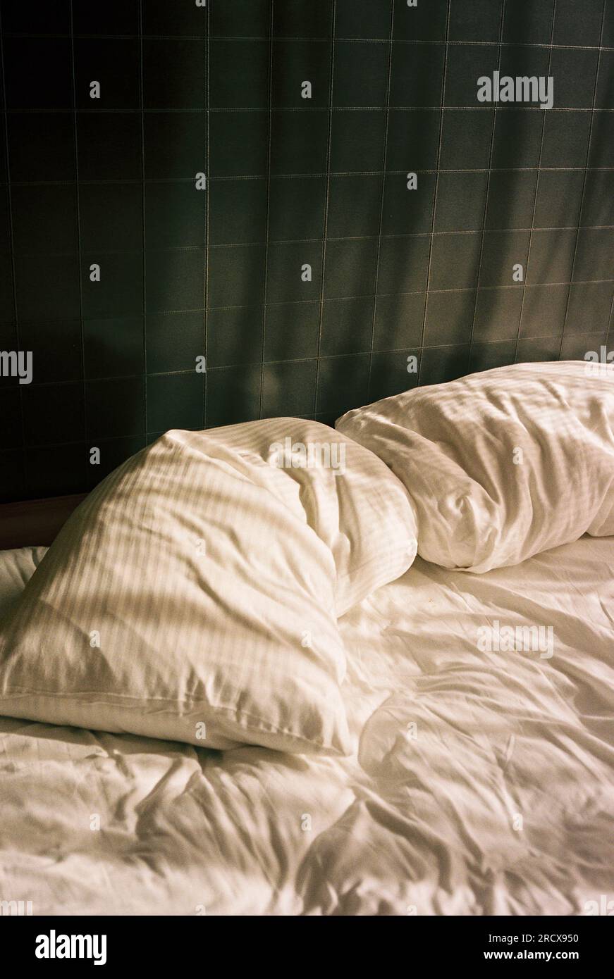 Une scène tranquille d'un lit de sommeil vide avec des draps blancs froissés Banque D'Images