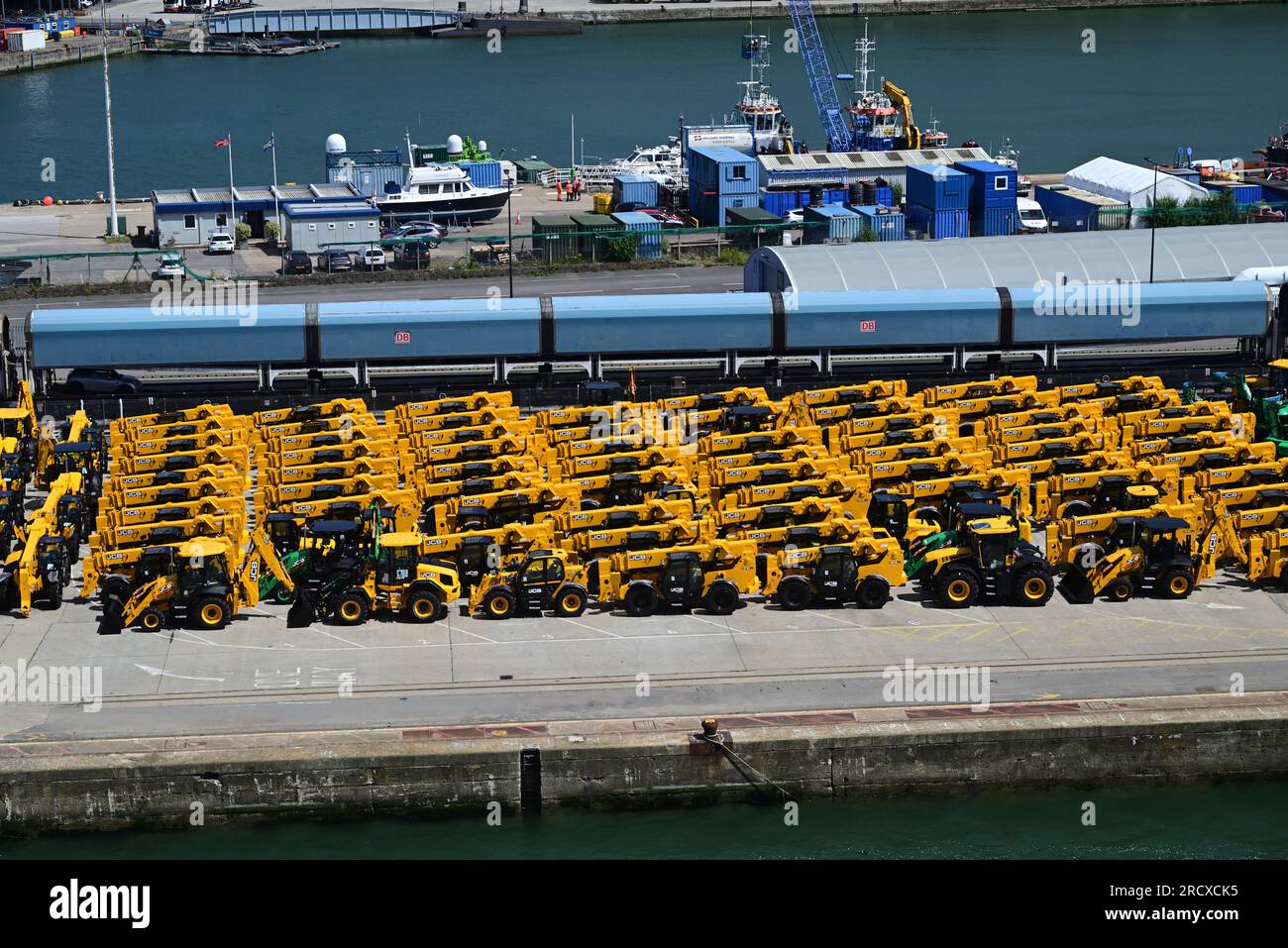 Un train porte-voitures et des JCB jaunes sur le quai des quais de Southampton. Banque D'Images