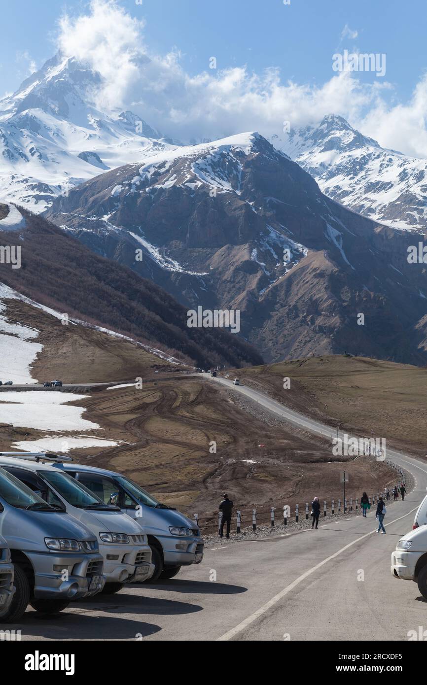 Stepantsminda, Géorgie - 1 mai 2019 : vue sur la rue Stepantsminda sur une journée ensoleillée, paysage de montagne géorgienne avec des gens marchant sur la route près de stationnement c Banque D'Images