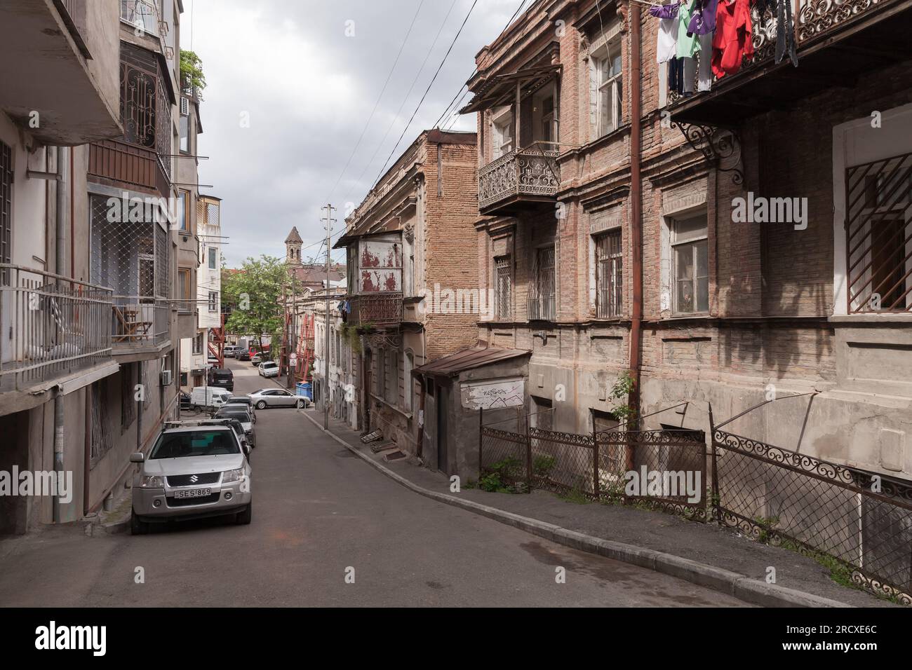 Tbilissi, Géorgie - 3 mai 2019 : vue sur la vieille rue de Tbilissi avec des voitures garées et des gens qui marchent Banque D'Images