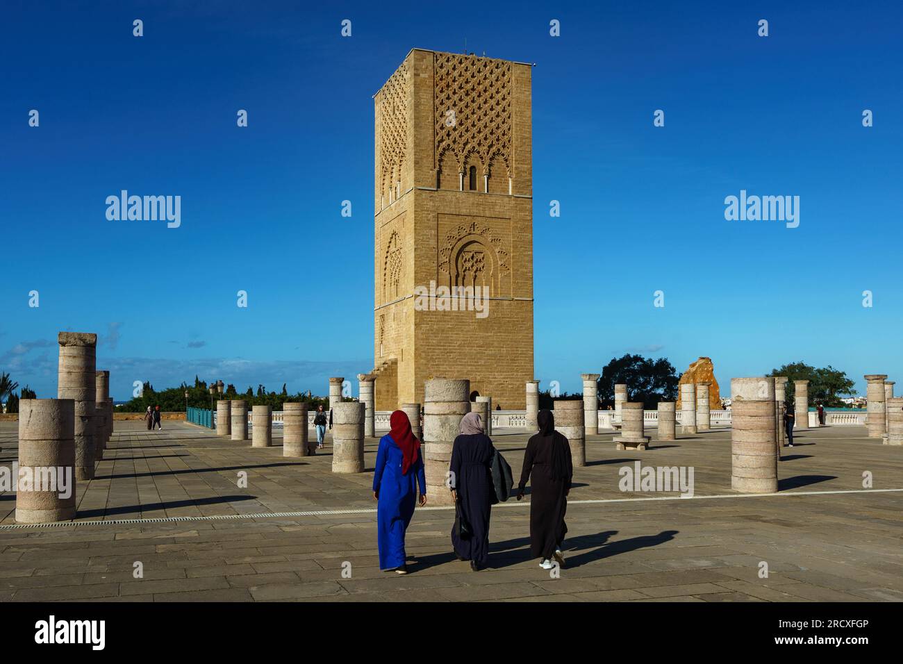 Maroc. Rabat. Un groupe de femmes se promènent devant la magnifique Tour Hassan et ses colonnes de pierre sur l’esplanade Yacoub al-Mansour. La tour est l'in Banque D'Images