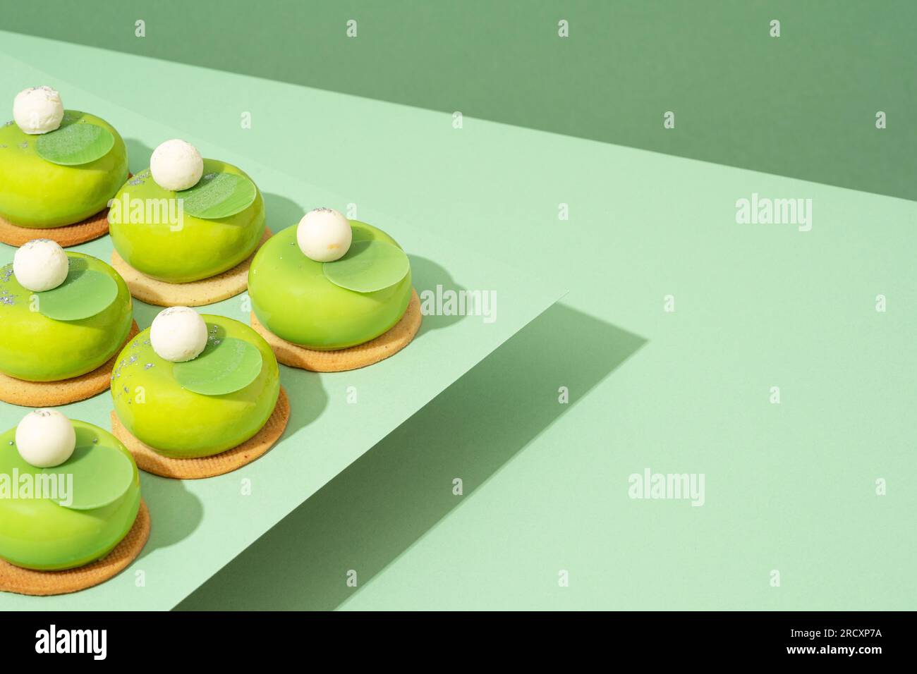 Un plateau de beignets verts assortis est posé sur une table en bois Banque D'Images
