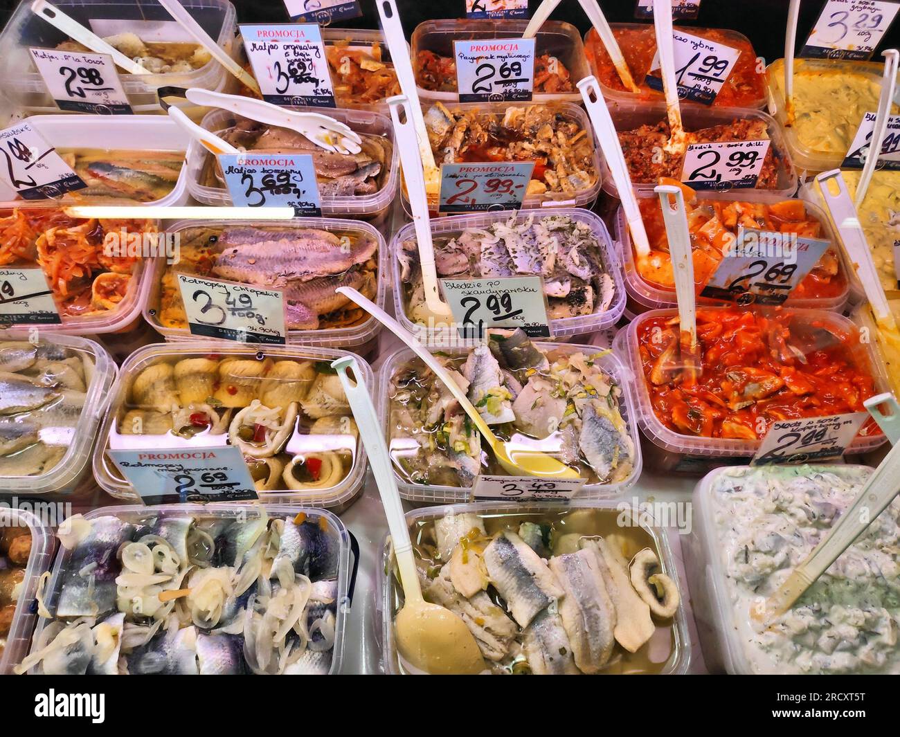KATOWICE, POLOGNE - 9 DÉCEMBRE 2022 : divers types de harengs marinés et salades de hareng avec étiquettes de prix dans un magasin spécialisé de poisson à Katowice, Polan Banque D'Images