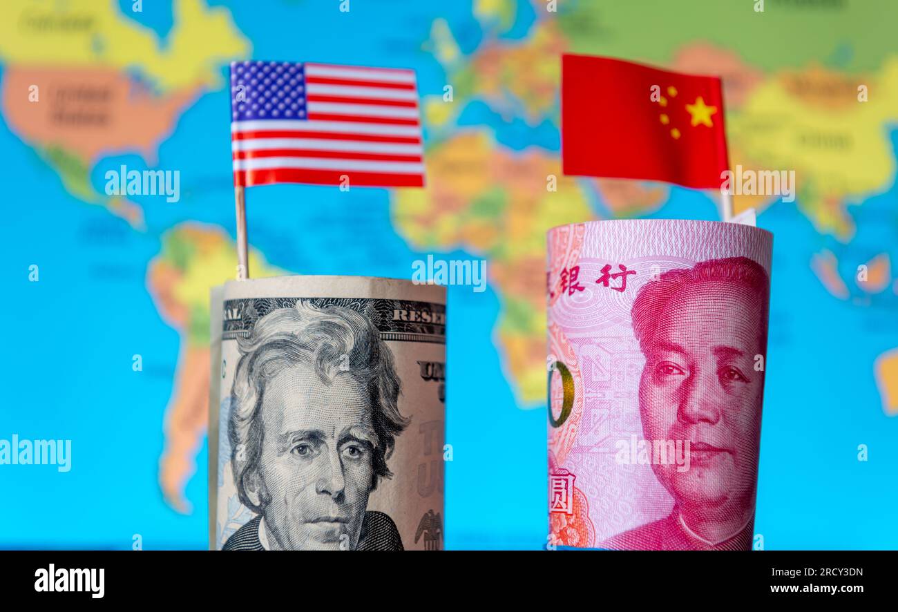 Un rouleau d'USD et de Yuan chinois avec le drapeau national de chaque pays avec une carte du monde en arrière-plan. Une concurrence mondiale de domination du commerce financier an Banque D'Images