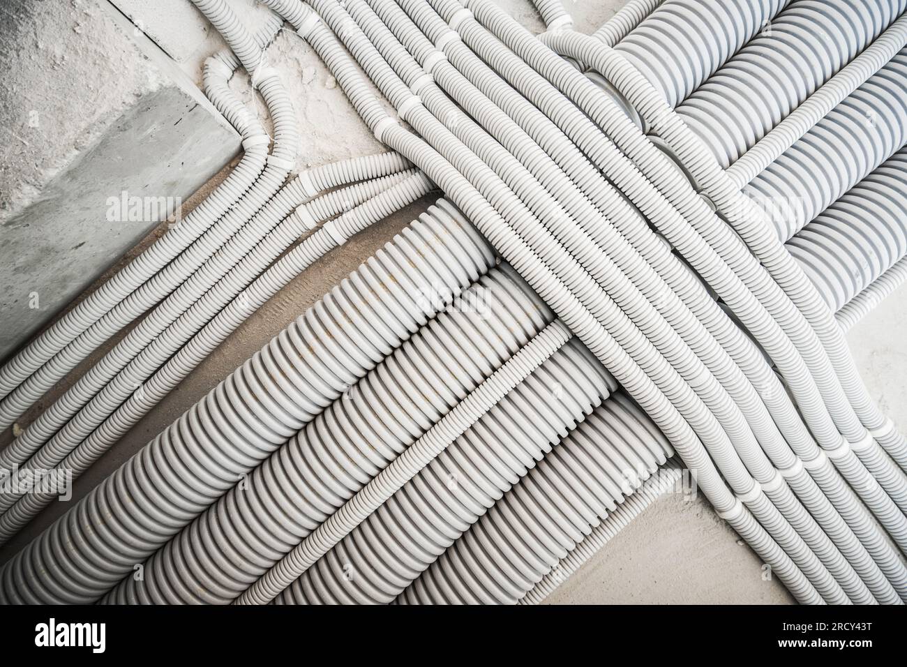 Conduits de système électrique en plastique installés le long d'un plancher. Thème industriel. Banque D'Images