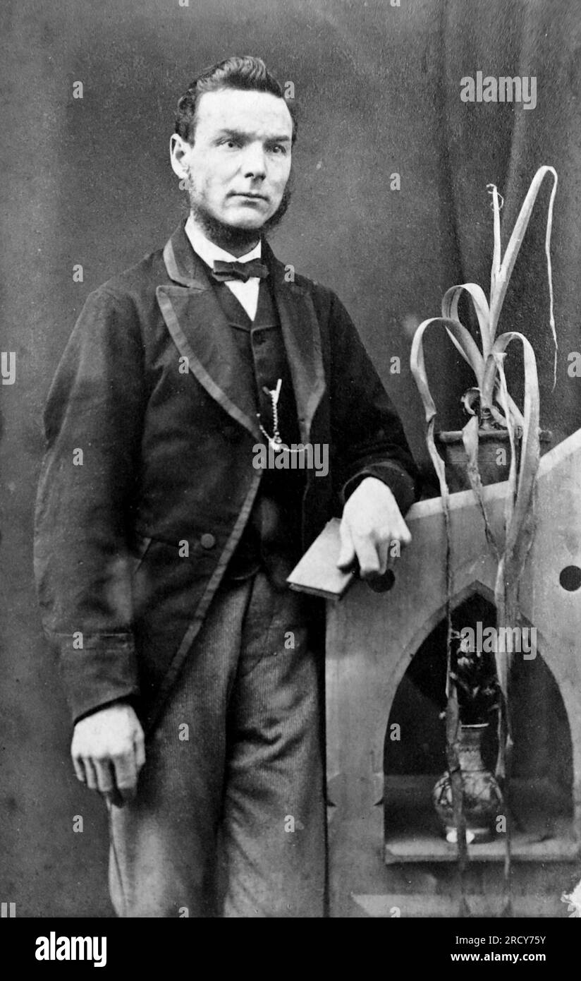 Portrait d'un jeune homme bien habillé debout à côté d'une plante en